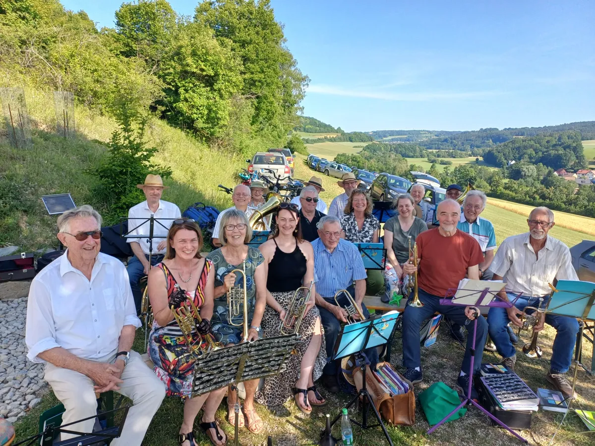 Blick auf die Mitglieder des Posaunenchors Trebgast sitzend bei sonnigem Wetter am Ranger